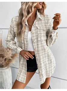 Detailed view of the woven tweed texture and golden pearl buttons on the plaid jacket