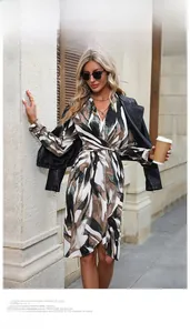 Detail of V-neck wrap dress with abstract marble print and black faux leather jacket