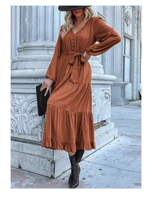 Detail view of V-neck long sleeve dress with button-up front and tiered skirt in rust red