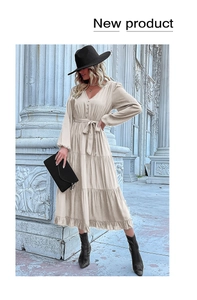 Detail of V-neck beige long-sleeve dress featuring button front and belted waist tie