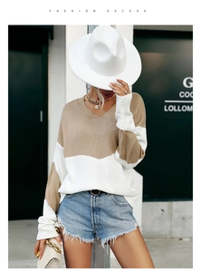Détail du pull en tricot bicolore kaki et blanc avec col en V et coupe décontractée