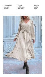 Detail of elegant V-neck beige maxi dress with button front and tiered ruffle hemline skirt