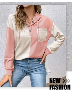 Dettaglio della felpa con cappuccio in maglia waffle rosa e beige con scollo Henley