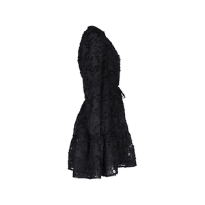 Detail of black long sleeve mini dress featuring 3D floral texture and ruffle hem