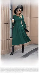 Close-up of smocked bodice and puff sleeves on a dark green A-line midi dress