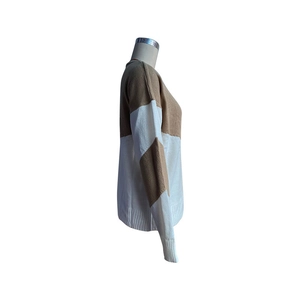 Détail des poignets côtelés et du motif à blocs de couleurs sur un pull en maille