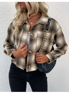 Détail d'une veste courte à carreaux marron avec boutons et poches poitrine