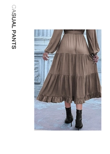 Close-up of brown tiered long dress featuring pleated fabric and ruffled hemline detail