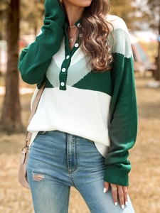 Detail of color-block knit sweater featuring a buttoned high neck and textured weave