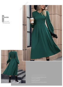 Close-up of smocked bodice and lantern sleeves on a dark green A-line midi dress