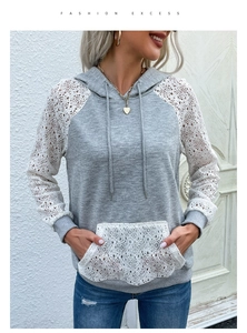Détail du patchwork en dentelle blanche sur le sweat à capuche gris clair à manches longues