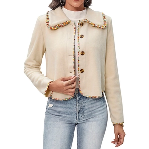 Close-up of cream short jacket with rainbow floral lace trim and tortoiseshell buttons