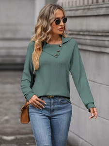 Detail of dark green textured sweatshirt featuring an asymmetric collar with buttons