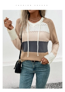 Detail of color-block knit sweater featuring crochet hollow sleeves and white hood drawstrings