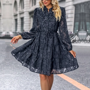 Detail of dark grey layered dress featuring 3D floral fringe texture and tiered skirt