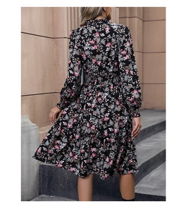 Detail of floral long sleeve midi dress showing tiered skirt and elastic waist design