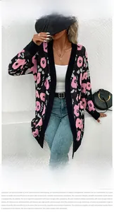 Détail du cardigan en maille avec motif floral abstrait rose sur tissu noir