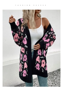 Détail du cardigan en maille épaisse avec motif floral jacquard rose sur fond noir