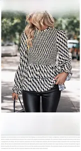 Detail of smocked chest design and ruffle edges on a black and white wavy stripe blouse