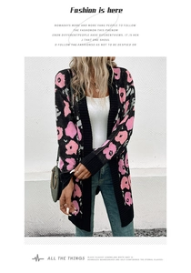 Détail du cardigan noir en tricot avec motifs floraux roses et poignets côtelés