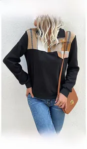 Close-up of long-sleeve pullover featuring textured fabric and plaid button collar detail