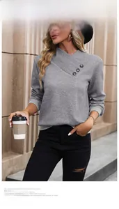 Détail d'un sweat gris texturé à manches longues avec col asymétrique et boutons
