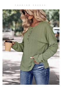 Gros plan d'un haut Henley vert avec motifs en maille texturée et boutons façon bois