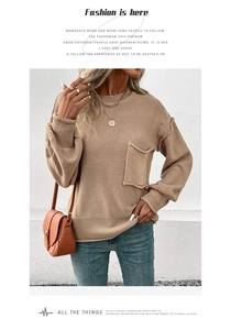 Close-up detail of the ribbed cuff and knit pocket on khaki long sleeve sweater