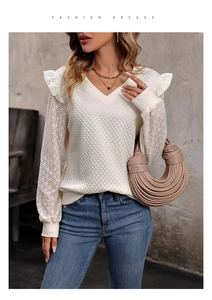 Detail of white ruffle trim and intricate lace cutout patterns on the sleeve fabric
