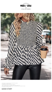 Detail of smocked waist and ruffled hem on black and white striped women's blouse