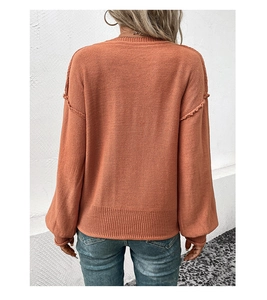 Vue détaillée du dos d'un pull en maille orange brûlé avec coutures aux épaules tombantes