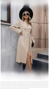 Dettaglio dell'abito beige a maniche lunghe con scollo a V, bottoni e spacco frontale