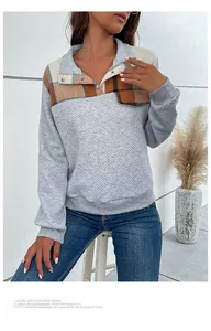 Detail of grey diamond-texture pullover with contrast plaid collar and button stand