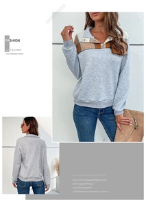 Detail of grey quilted pullover with brown plaid collar and buttoned neckline