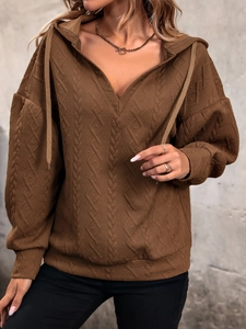 Detailed view of coffee brown knit hoodie with 3D geometric embossed texture and V-neckline