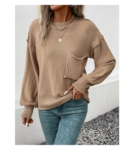 Detail of camel knit sweater featuring raw-edge pocket and visible seam stitching