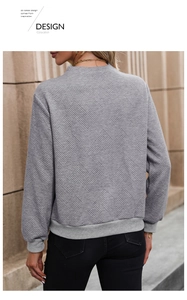 Vue détaillée du sweat-shirt gris avec motif gaufré en losange et poignets côtelés