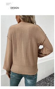 Detailed back view of khaki knit sweater showing exposed seams and ribbed sleeve cuffs