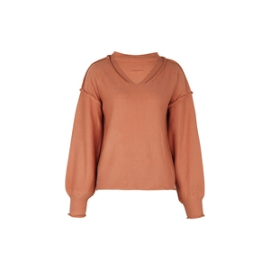 Détail d'un pull en maille avec coutures apparentes et poignets côtelés larges