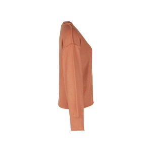 Détail du pull en maille orange corail avec coutures apparentes et poignets côtelés