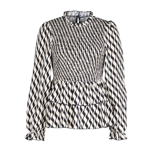 Detailed view of smocked bodice and ruffled hem on black and white striped blouse