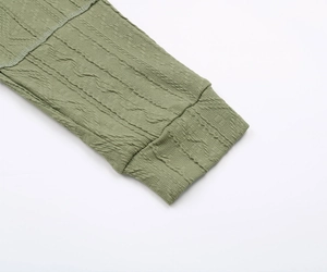 Vue macro détaillée de la texture tricotée vert olive et de la couture du poignet sur le haut