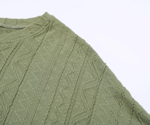 Détail du haut en tricot vert menthe montrant la texture jacquard et le col rond ajusté