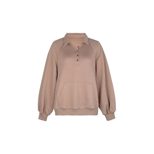 Détail de la texture matelassée en losange et du col polo sur le sweat rose poudré