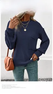 Detail of navy blue crewneck knit sweater featuring a decorative chest pocket and ribbed cuffs