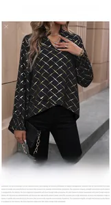 Detail of the golden grid pattern and pleated cuffs on a black V-neck long sleeve blouse