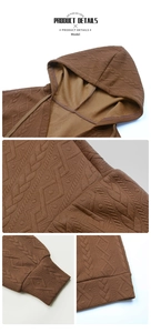 Close-up of brown textured knit hoodie showing 3D jacquard pattern and seam details