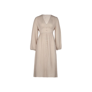 Dettaglio dell'abito beige testurizzato con scollo a V, bottoni decorativi e girovita