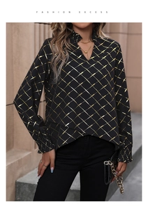 Detail of black V-neck top with gold foil lattice print and layered asymmetric hemline