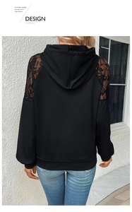 Detail van zwarte hoodie met elegante kant-inzetstukken op schouders en lange mouwen